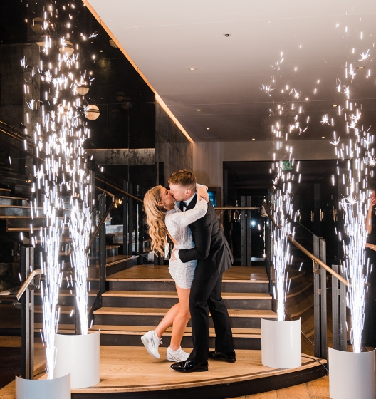 bride and groom kissing in between fireworks