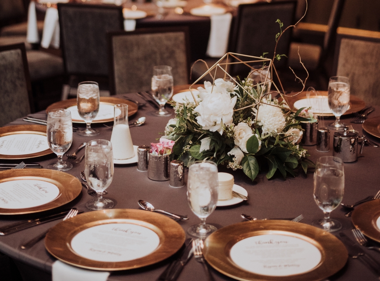 a formal dining table set with flowers and place settings