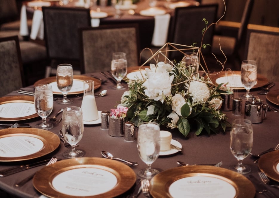 a formal dining table set with flowers and glasses