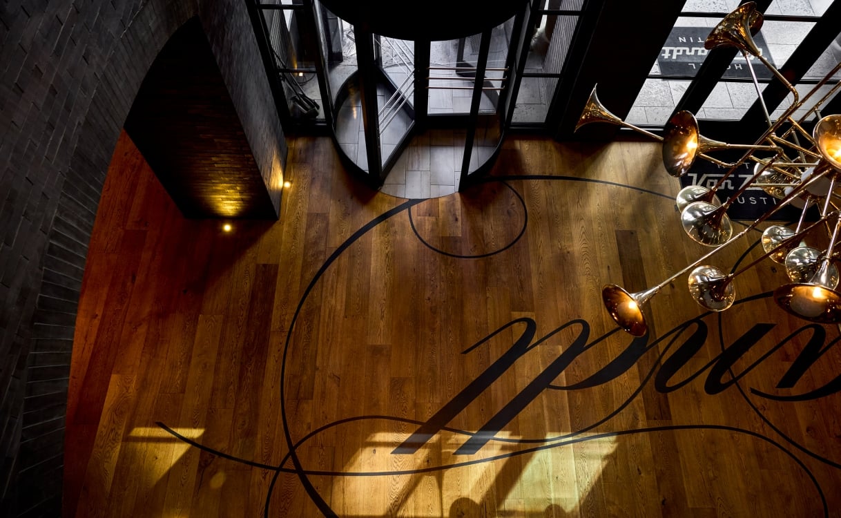 a lobby with a wooden floor and a brass horn chandelier