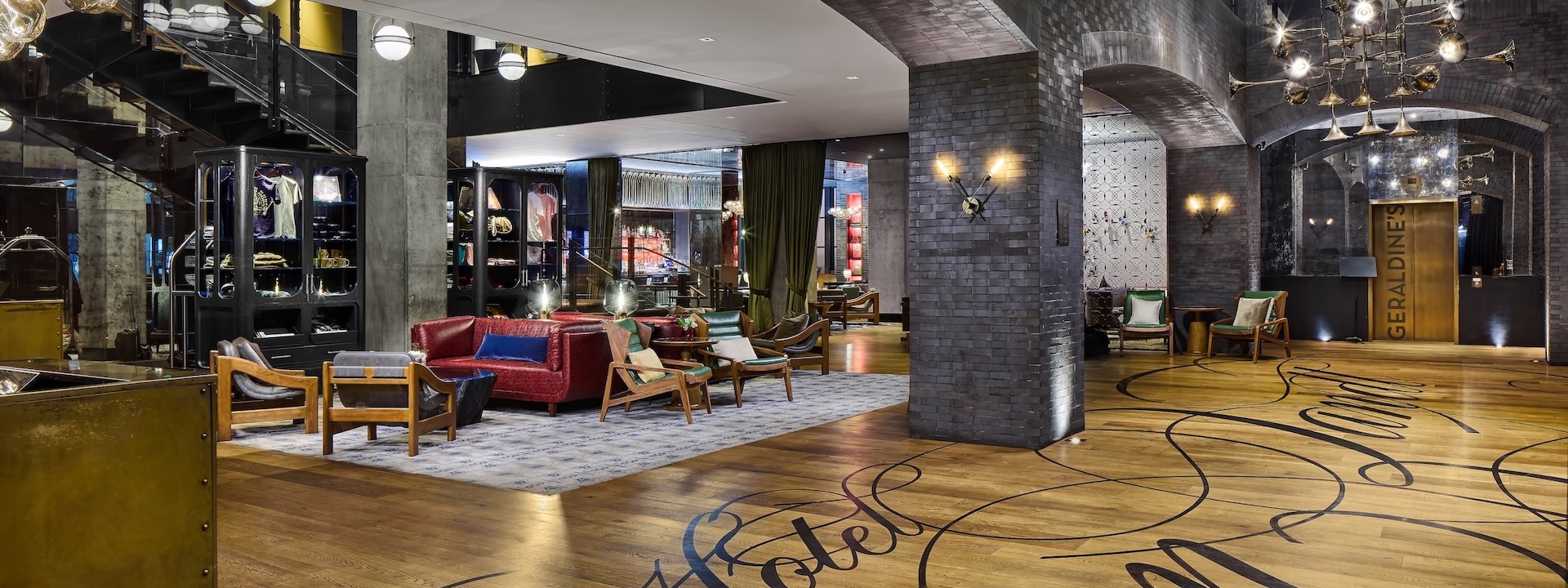 A spacious lobby with a seating area, wood floor, and decorative lighting.