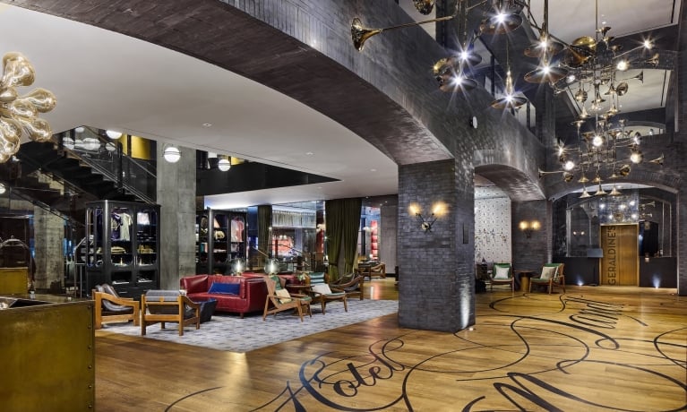 A spacious lobby with modern furniture and unique lighting fixtures.