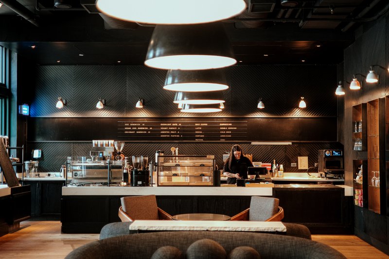 Café 605 espresso bar with barista, pastry case, and lounge seating