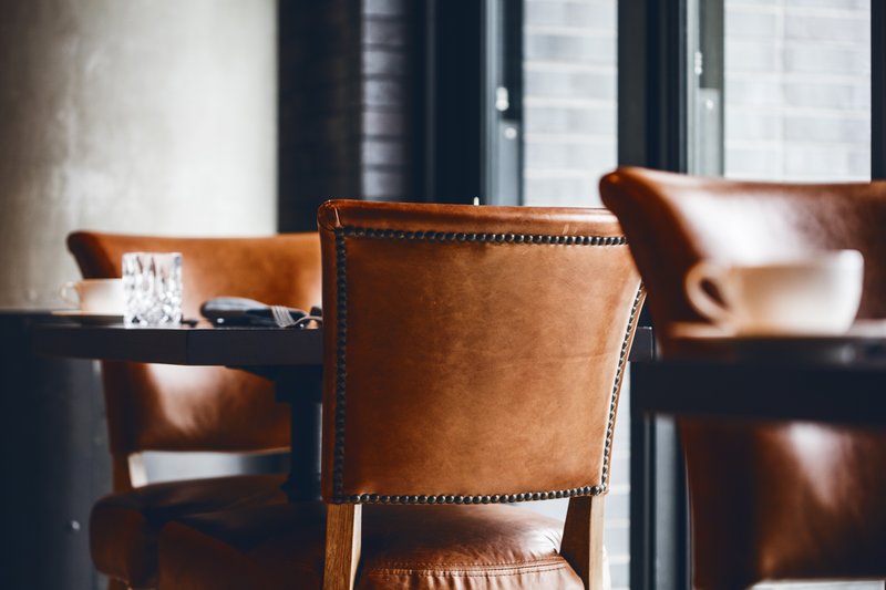 Geraldine's dining room with leather armchairs and floor-to-ceiling windows
